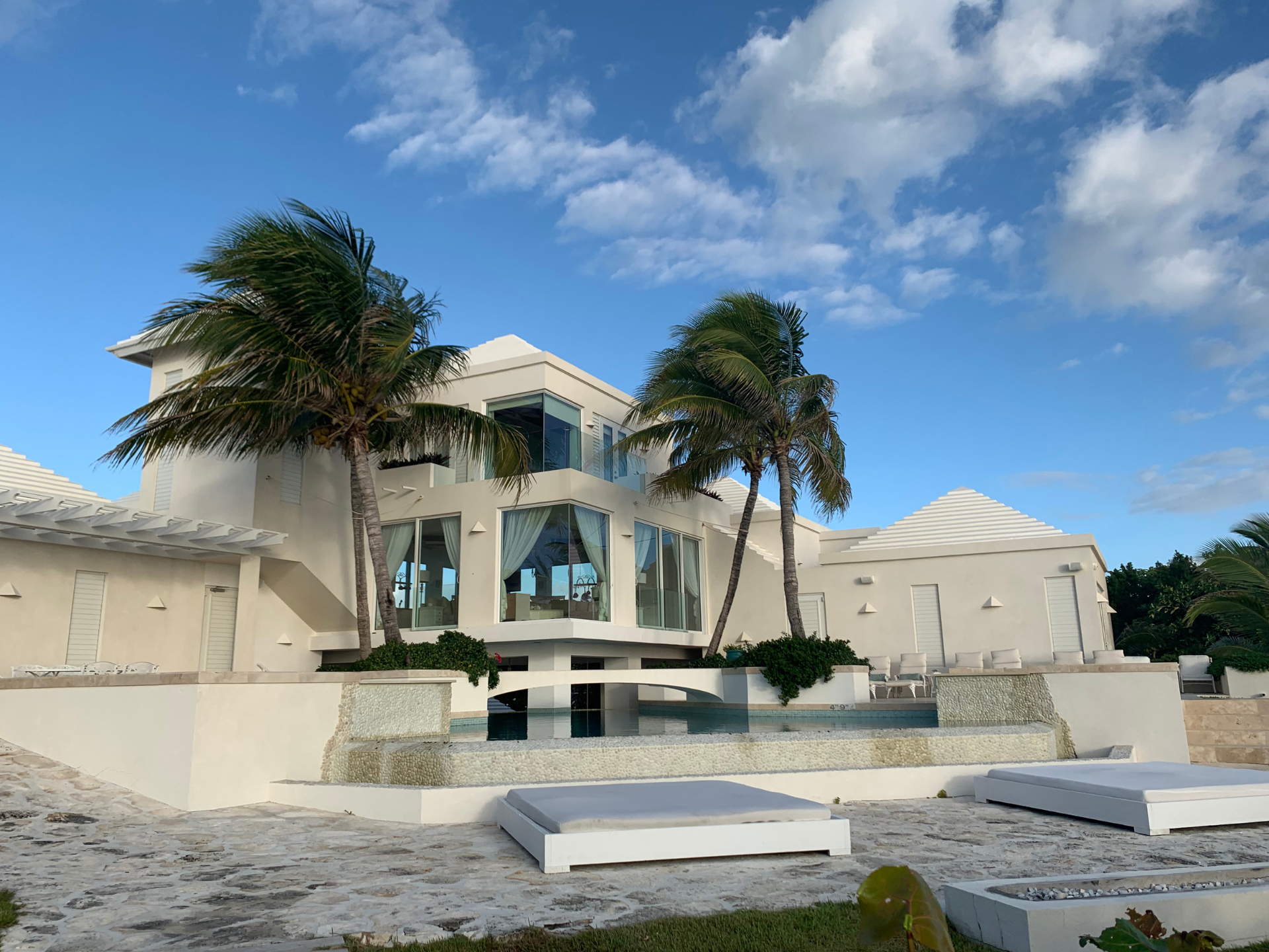 Private beachfront villa with pool and palm trees on Long Bay, Turks and Caicos